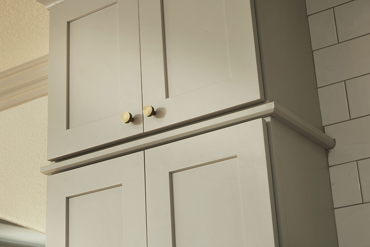 aged brass knobs on light gray shaker cabinets