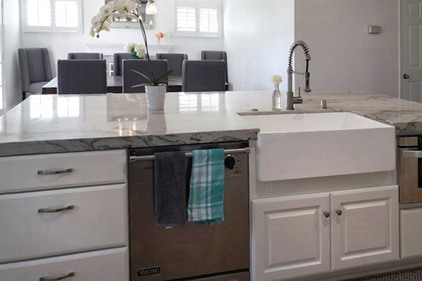 Kitchen island with white cabinets, dishwasher, apron sink and microwave facing the formal dining room Kitchen island with white cabinets, dishwasher, apron sink and microwave facing the formal dining room