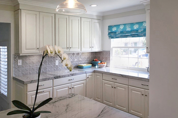 Corner of kitchen with white Decorative cabinets, gray tile backsplash and a window Corner of kitchen with white Decorative cabinets, gray tile backsplash and a window