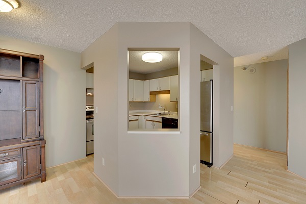 an empty condo with a kitchen with a peek-a-boo window to the living area. an empty condo with a kitchen with a peek-a-boo window to the living area.