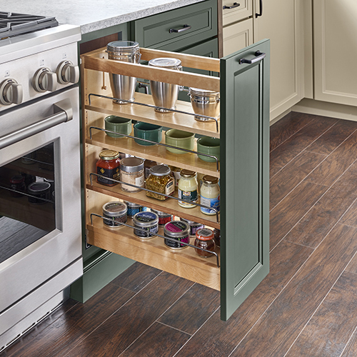 Pull-out spice cabinet with multiple adjustable shelves next to range appliance with painted green cabinet door Pull-out spice cabinet with multiple adjustable shelves next to range appliance with painted green cabinet door
