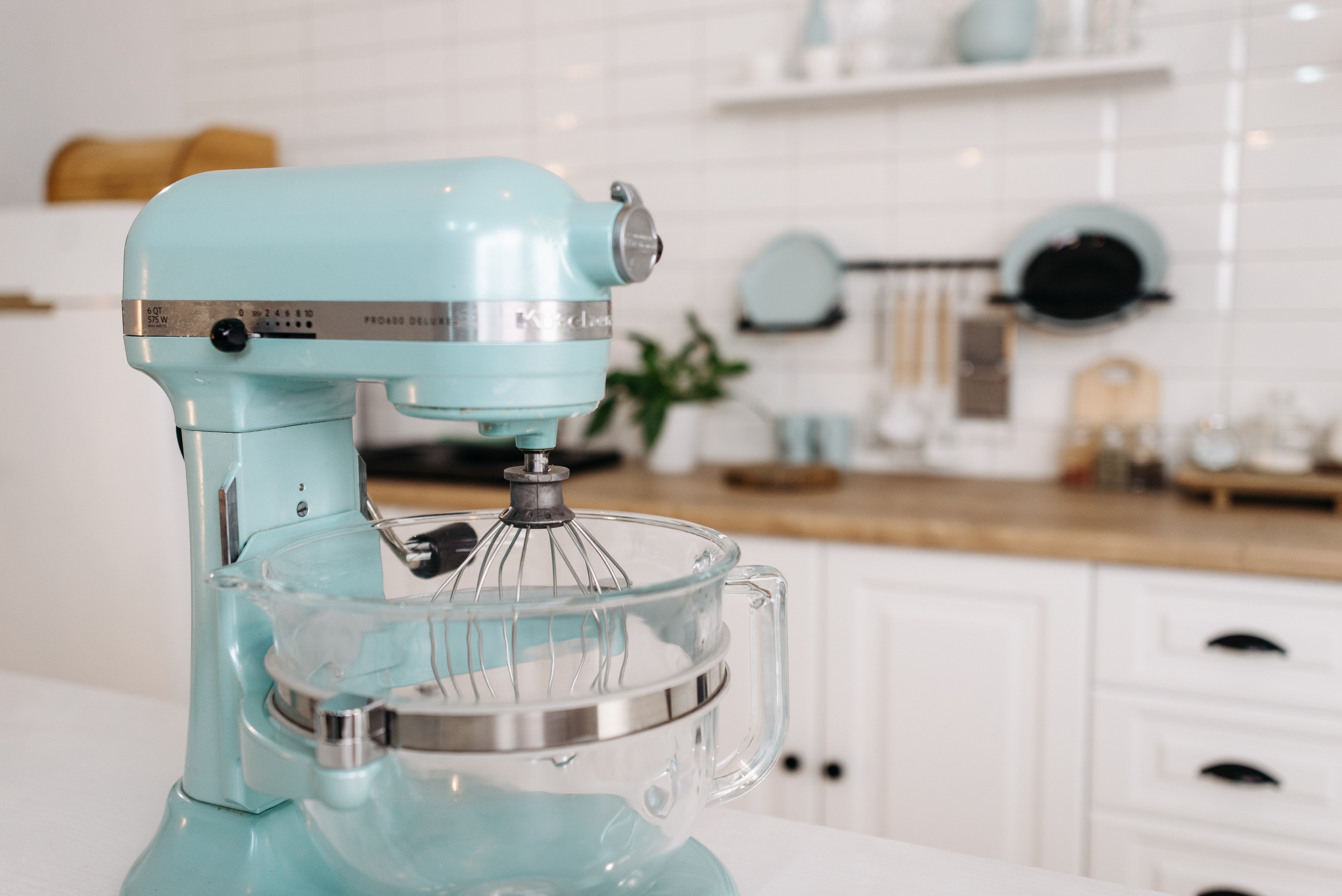 Aqua blue KitchenAid stand mixer sitting on decorative white kitchen cabinets Aqua blue KitchenAid stand mixer sitting on decorative white kitchen cabinets