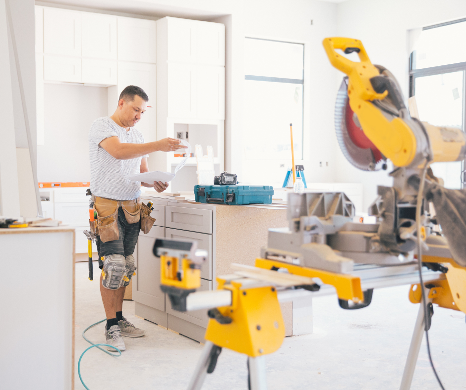 White shaker kitchen cabinets being installed by contractor surrounded by power tools White shaker kitchen cabinets being installed by contractor surrounded by power tools