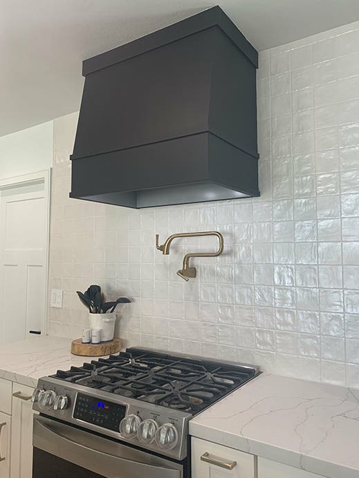 Angled wood range hood painted black in white shaker kitchen Angled wood range hood painted black in white shaker kitchen