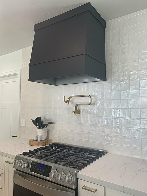 White kitchen cabinets with angled wood kitchen hood in black finish White kitchen cabinets with angled wood kitchen hood in black finish