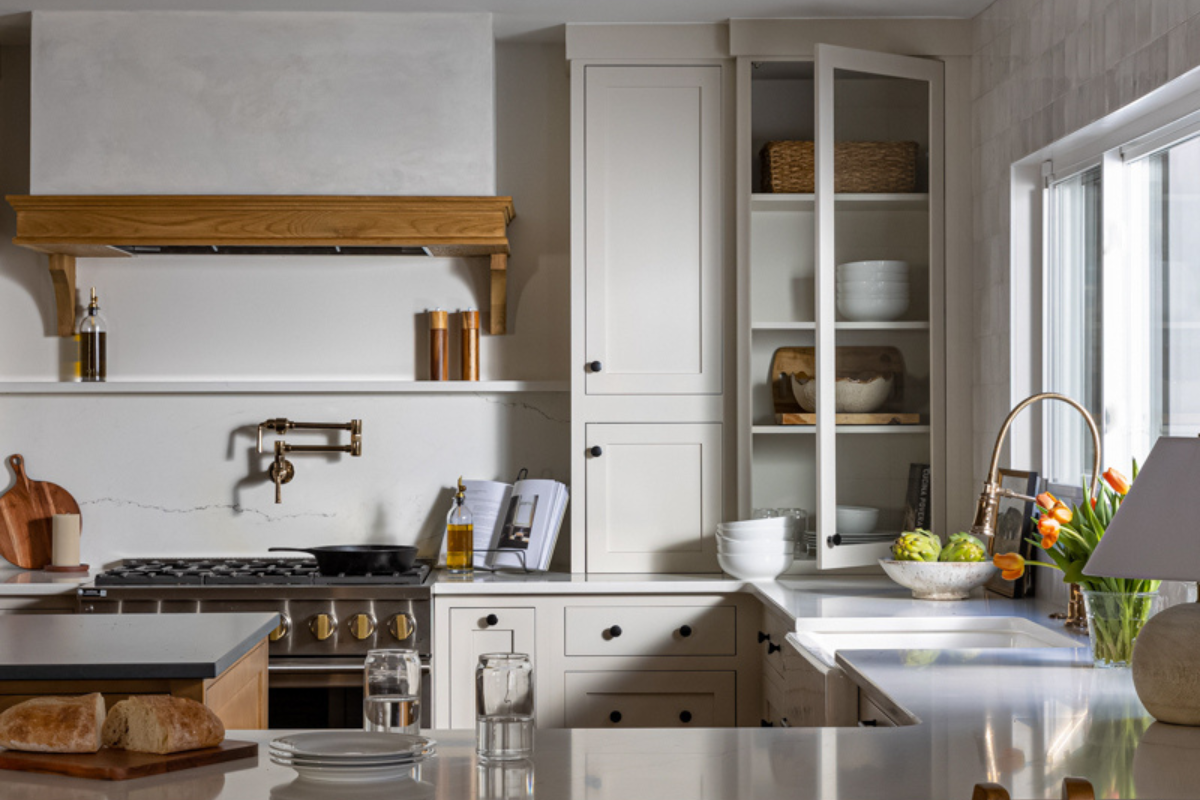 Light cream inset kitchen cabinet design with medium wood accents and plaster kitchen hood Light cream inset kitchen cabinet design with medium wood accents and plaster kitchen hood