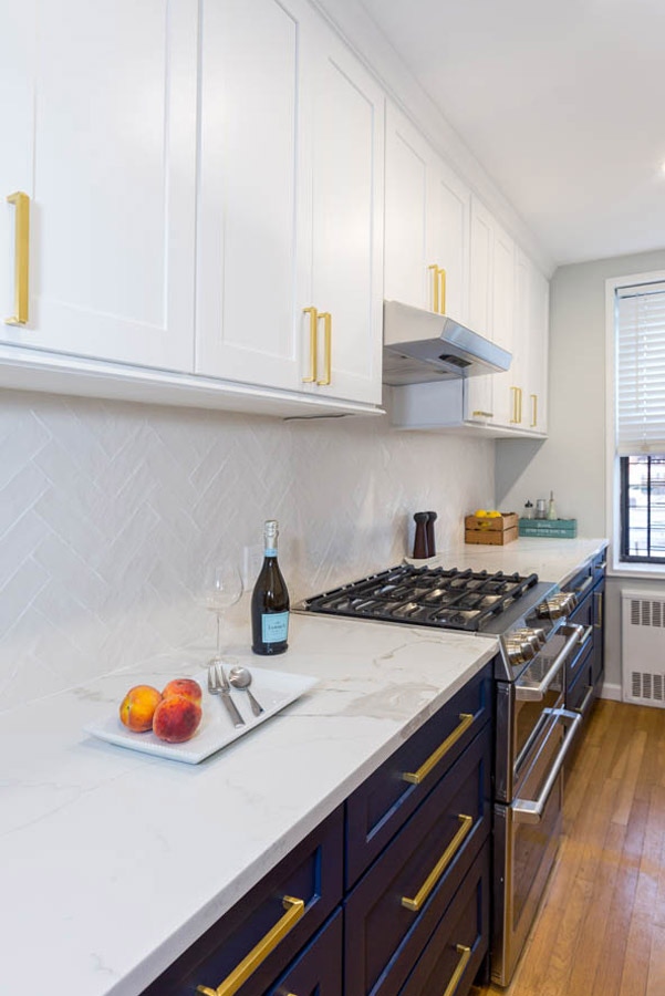 blue and white cabinets with brass bar hardware and white pearlescent, herringbone backsplash blue and white cabinets with brass bar hardware and white pearlescent, herringbone backsplash
