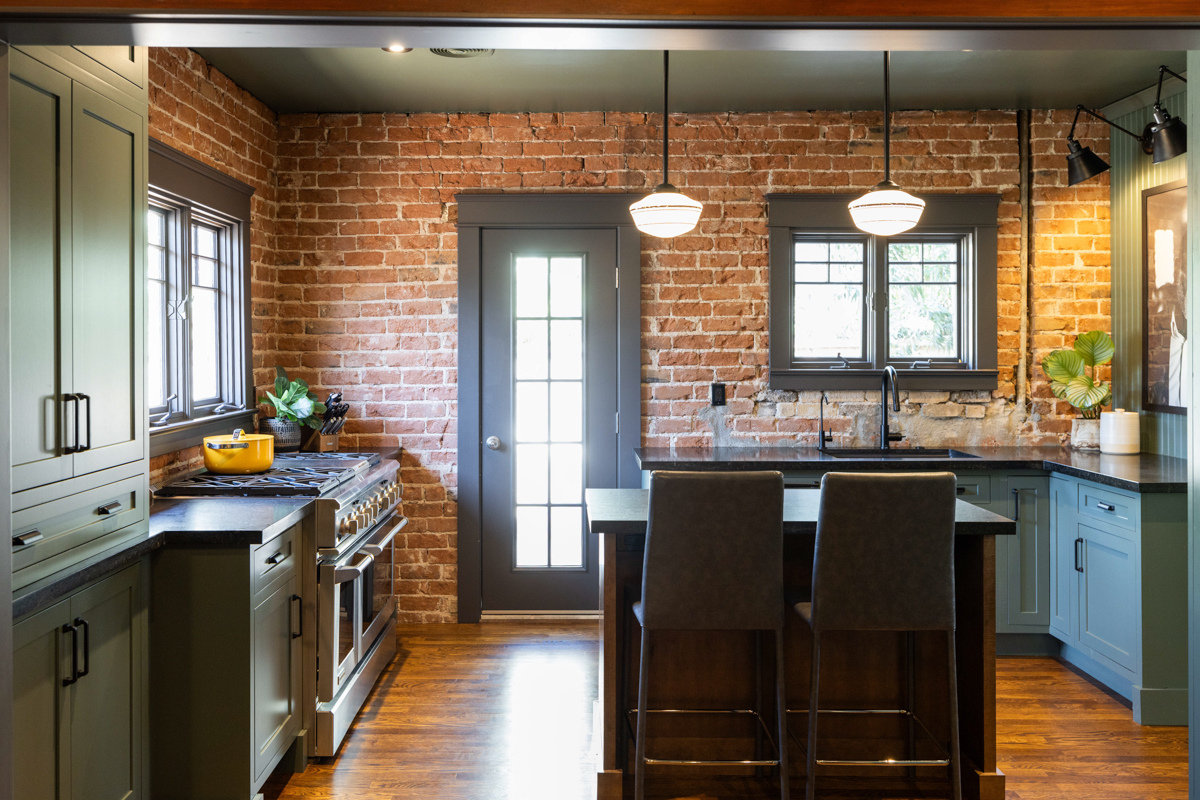 U-shaped large green kitchen with inset cabinets, vintage elements and dark brown island with black granite countertops and hardware U-shaped large green kitchen with inset cabinets, vintage elements and dark brown island with black granite countertops and hardware