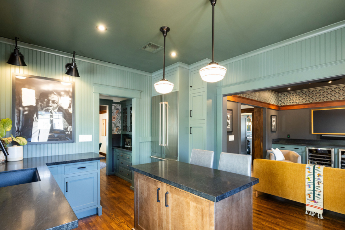 U-shaped large green kitchen with inset cabinets, vintage elements and dark brown island with black granite countertops and hardware U-shaped large green kitchen with inset cabinets, vintage elements and dark brown island with black granite countertops and hardware