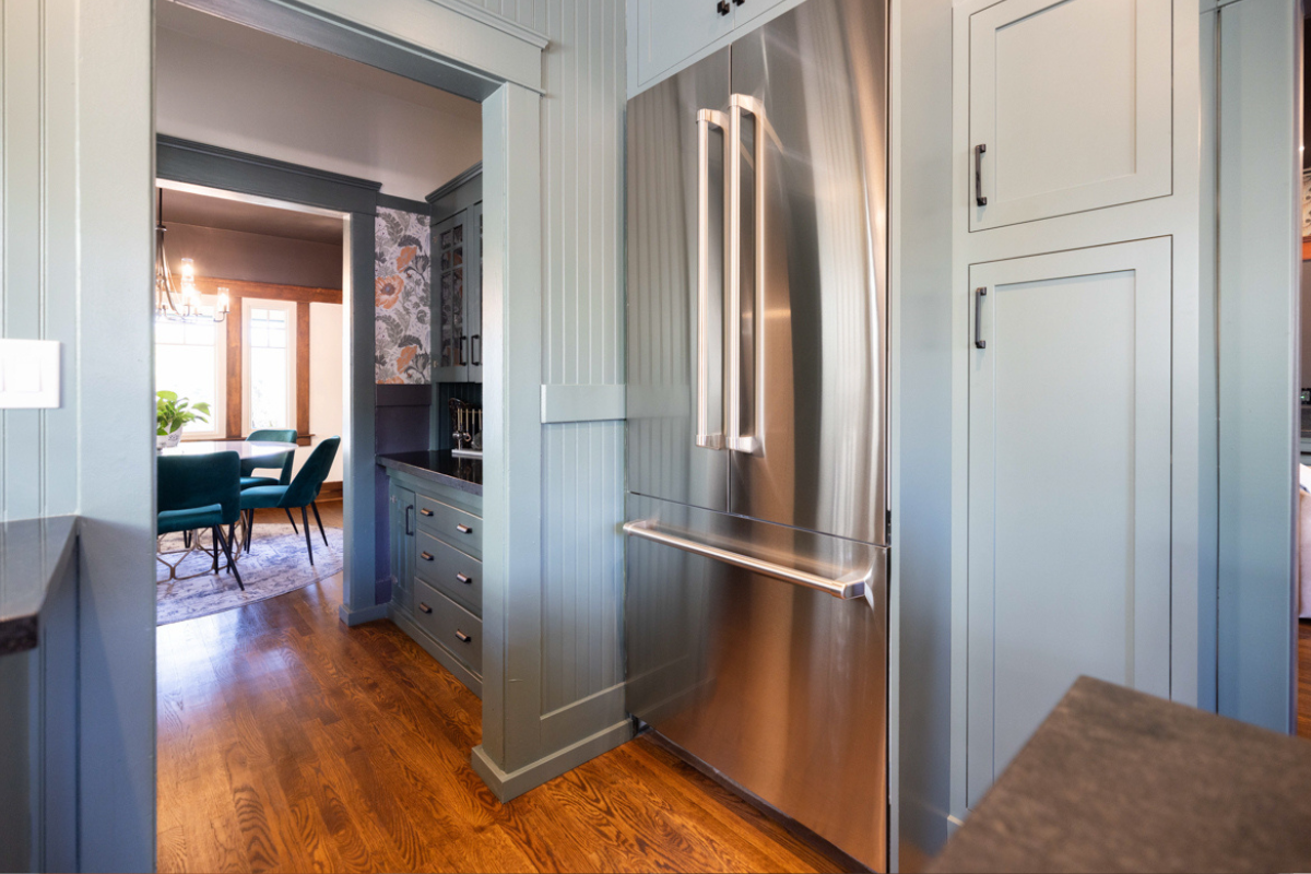 U-shaped large green kitchen with inset cabinets, vintage elements and dark brown island with black granite countertops and hardware U-shaped large green kitchen with inset cabinets, vintage elements and dark brown island with black granite countertops and hardware