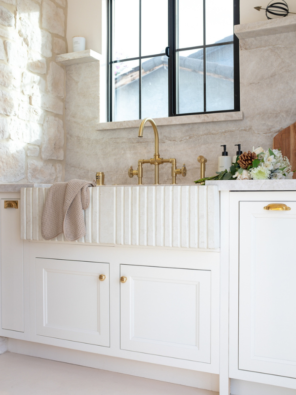 White inset kitchen cabinets with a fluted white farmhouse sink and a black framed window above White inset kitchen cabinets with a fluted white farmhouse sink and a black framed window above
