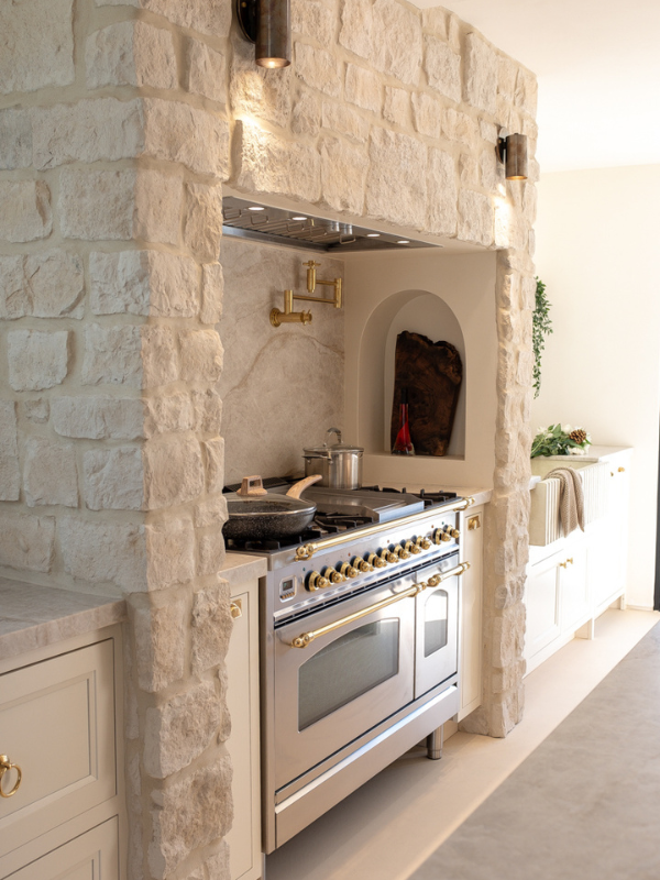 Mediterranean kitchen range wall with white inset base cabinets and a natural limestone range alcove Mediterranean kitchen range wall with white inset base cabinets and a natural limestone range alcove