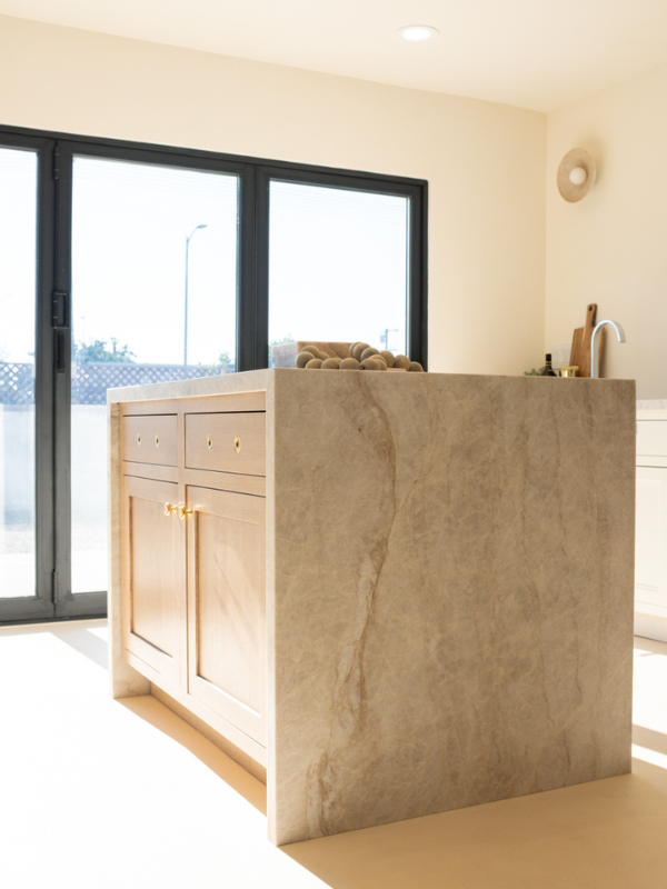 Light wood kitchen island with inset shaker door style, brass hardware and waterfall quartzite countertops Light wood kitchen island with inset shaker door style, brass hardware and waterfall quartzite countertops