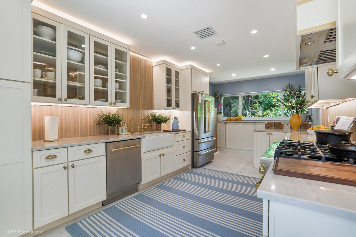 Soft white shaker kitchen cabinets with brass hardware and a modern wood slat backsplash Soft white shaker kitchen cabinets with brass hardware and a modern wood slat backsplash
