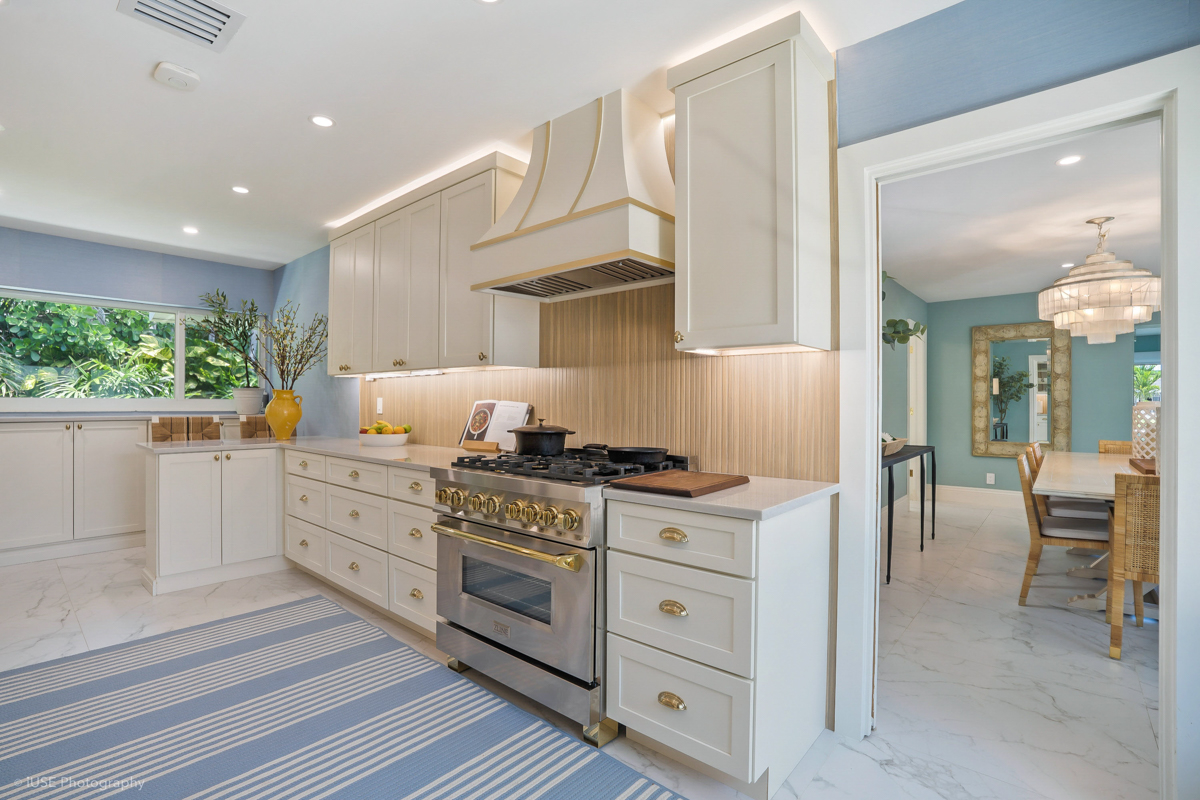 Soft white shaker kitchen cabinets with brass hardware and a modern wood slat backsplash Soft white shaker kitchen cabinets with brass hardware and a modern wood slat backsplash