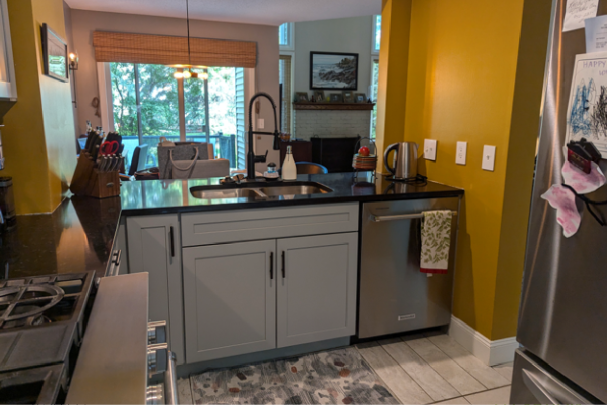 Gray shaker kitchen cabinets with black cabinet hardware and yellow walls