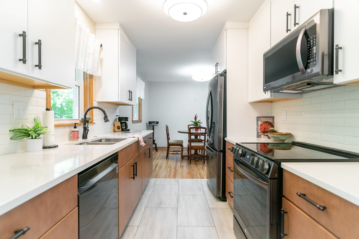 White slab kitchen wall cabinets with light brown slab base cabinets and black hardware White slab kitchen wall cabinets with light brown slab base cabinets and black hardware