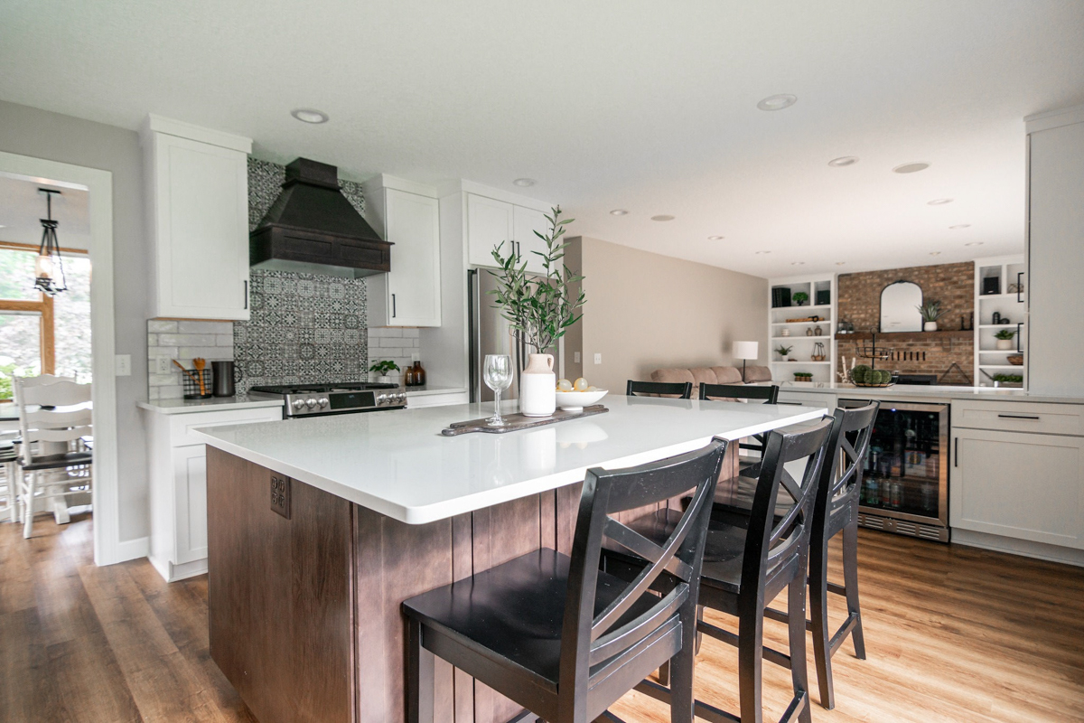 White shaker kitchen and crown molding with dark brown kitchen hood and island with white quartz countertops White shaker kitchen and crown molding with dark brown kitchen hood and island with white quartz countertops