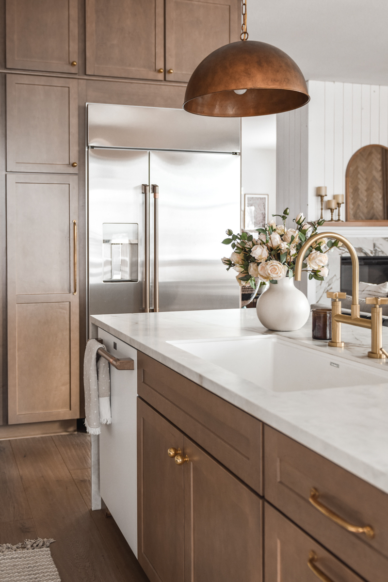 Light wood shaker kitchen cabinets and island with a cream-colored half waterfall island countertop Light wood shaker kitchen cabinets and island with a cream-colored half waterfall island countertop