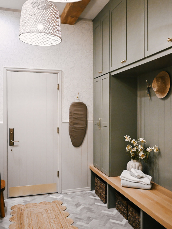 Right side of the laundry room with light olive mudroom lockers flanking a white oak bench with woven baskets below and cement pavers in herringbone floor pattern Right side of the laundry room with light olive mudroom lockers flanking a white oak bench with woven baskets below and cement pavers in herringbone floor pattern