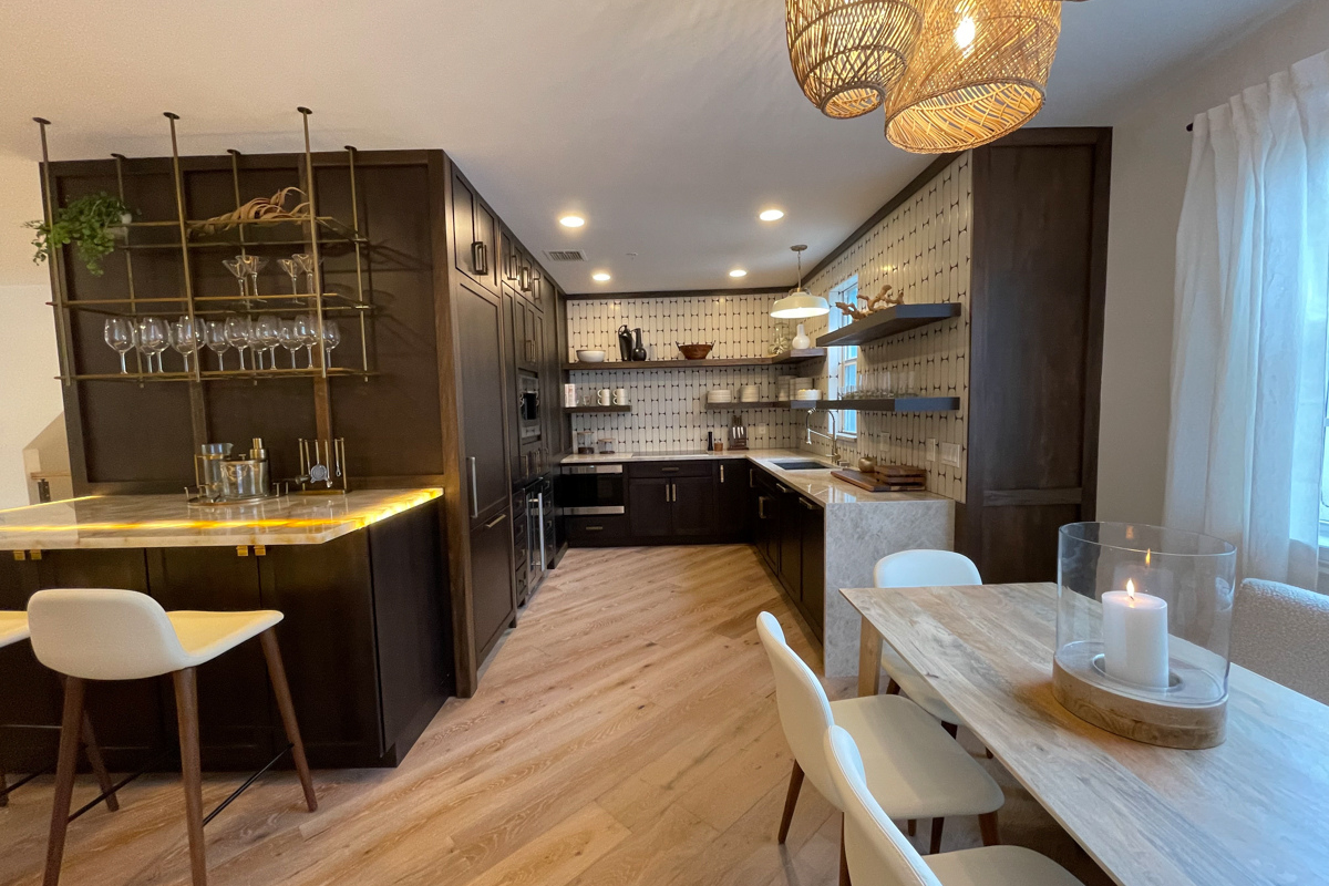 Small and chic U-shaped kitchen in dark brown shaker cabinets with wood floating shelves, white funky tile backsplash, and light brown quartz countertop with waterfall edge detail Small and chic U-shaped kitchen in dark brown shaker cabinets with wood floating shelves, white funky tile backsplash, and light brown quartz countertop with waterfall edge detail