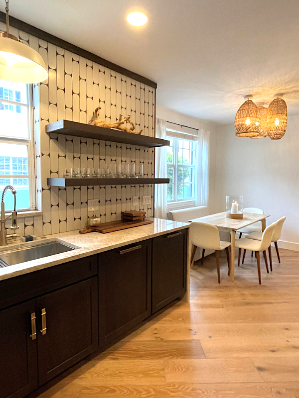 Dark brown shaker base cabinets on the sink wall of a kitchen design with floating wood shelves and a funky white subway tile backsplash Dark brown shaker base cabinets on the sink wall of a kitchen design with floating wood shelves and a funky white subway tile backsplash