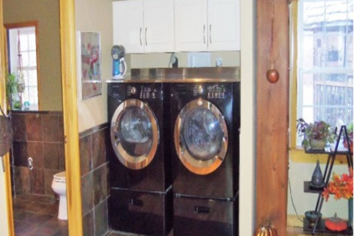 White shaker wall cabinets suspended over a frontload washer and dryer White shaker wall cabinets suspended over a frontload washer and dryer