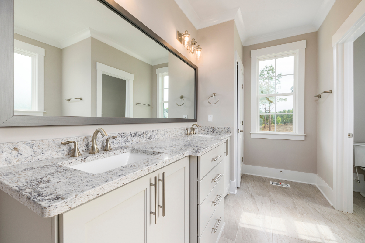 Decorative white bathroom vanity with light granite countertops and brushed nickel fixtures Decorative white bathroom vanity with light granite countertops and brushed nickel fixtures