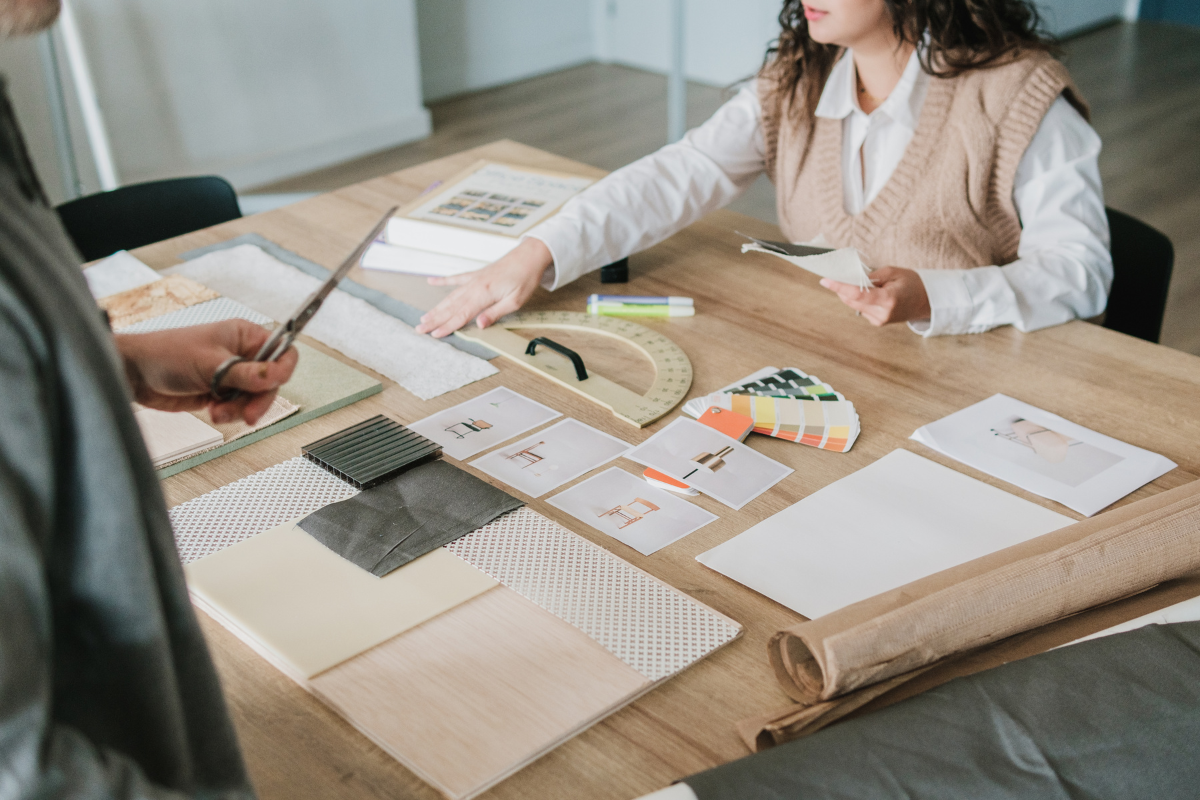 Interior designer comparing fabrics and finishes for a home remodel on a table Interior designer comparing fabrics and finishes for a home remodel on a table