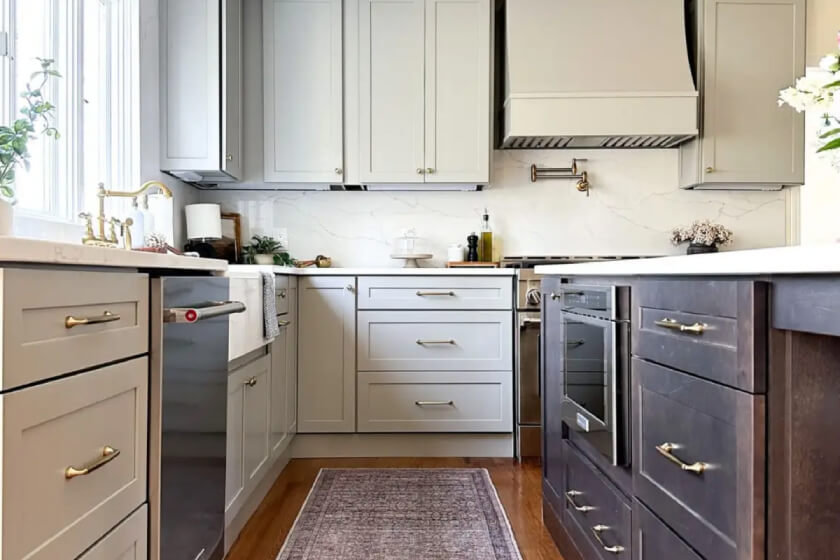 Duluth Pebble and Newport Chai kitchen cabinets Light gray shaker kitchen with dark wood stained island and white marble-like countertops