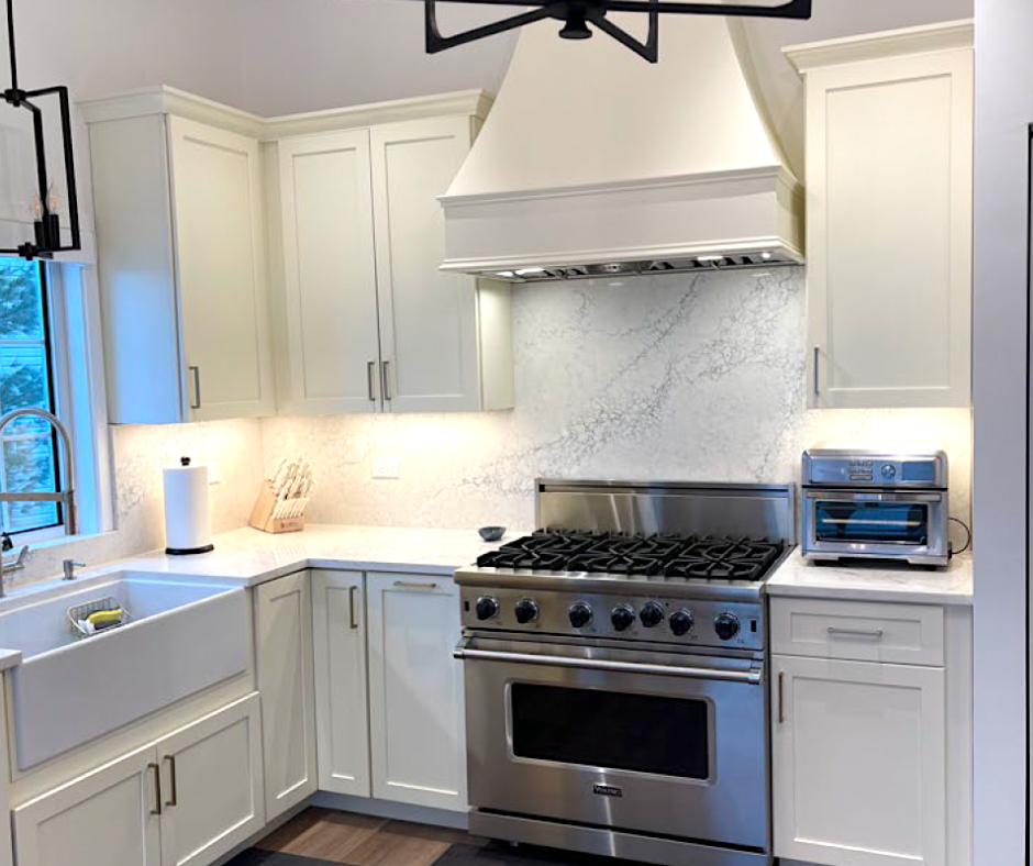 CliqStudios project: cream-colored shaker kitchen cabinets with a matching wood hood and large stainless steel gas range CliqStudios project: cream-colored shaker kitchen cabinets with a matching wood hood and large stainless steel gas range
