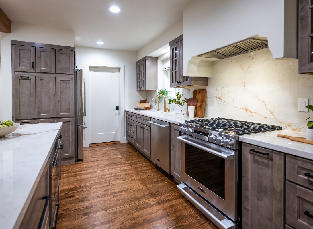 CliqStudios project: Light gray-brown stained kitchen cabinets with mullion doors, cream countertops, and a slab backsplash CliqStudios project: Light gray-brown stained kitchen cabinets with mullion doors, cream countertops, and a slab backsplash