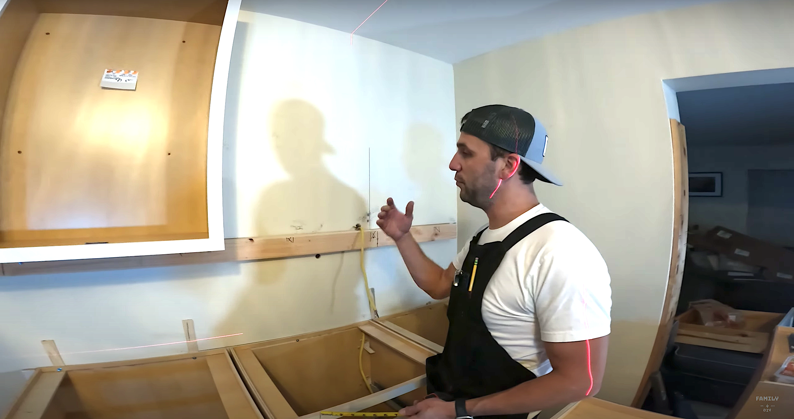 Mike Sante of Family DIY TV using a ledger rail to support wall cabinets during cabinet installation Mike Sante of Family DIY TV using a ledger rail to support wall cabinets during cabinet installation