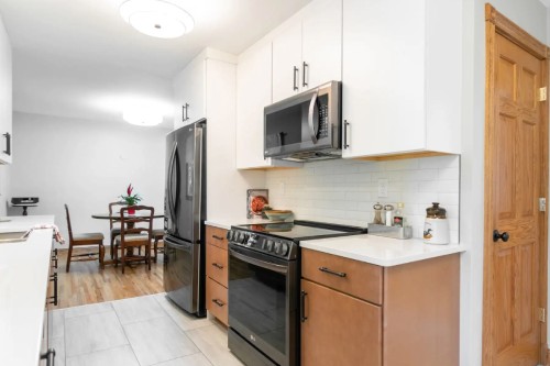 Slab cabinet door kitchen with white wall cabinets and light wood base cabinets Galley-style slab cabinet door kitchen with white wall cabinets and light wood base cabinets