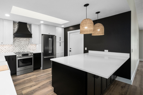 Harrison Carriage Black and Sea Salt kitchen cabinets Large L-shaped kitchen design with black shaker base and island cabinets and white shaker wall cabinets with white quartz countertops