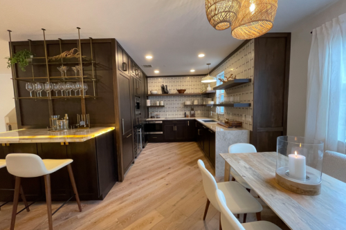 Harrison Smoke kitchen cabinets U-shaped upscale loft kitchen with dark brown kitchen cabinets, floating shelves throughout, modern white vertical tile backsplash for kitchen cabinets and waterfall quartz countertops