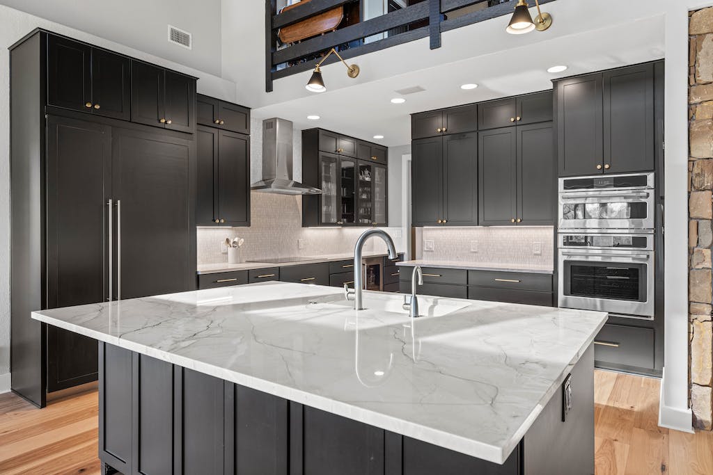 CliqStudios project: Black shaker kitchen cabinets with a white stone countertop and rustic beams above CliqStudios project: Black shaker kitchen cabinets with a white stone countertop and rustic beams above
