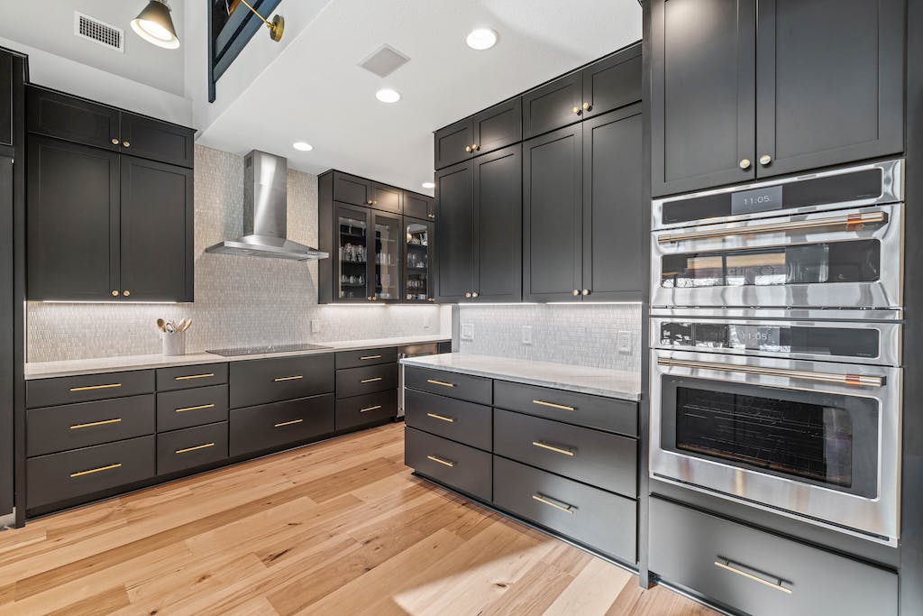 CliqStudios project: Black shaker kitchen cabinets with a white stone countertop and rustic beams above CliqStudios project: Black shaker kitchen cabinets with a white stone countertop and rustic beams above