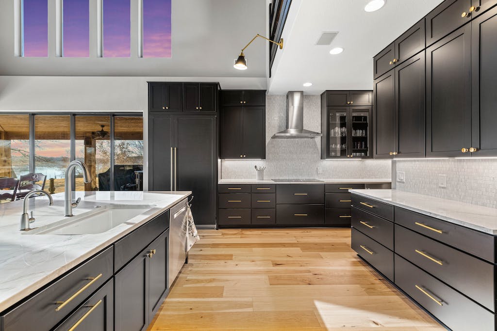 CliqStudios project: Black shaker kitchen cabinets with a white stone countertop and rustic beams above CliqStudios project: Black shaker kitchen cabinets with a white stone countertop and rustic beams above