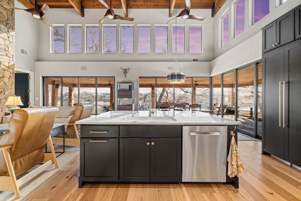 CliqStudios project: Black shaker kitchen cabinets with a white stone countertop and rustic beams above CliqStudios project: Black shaker kitchen cabinets with a white stone countertop and rustic beams above