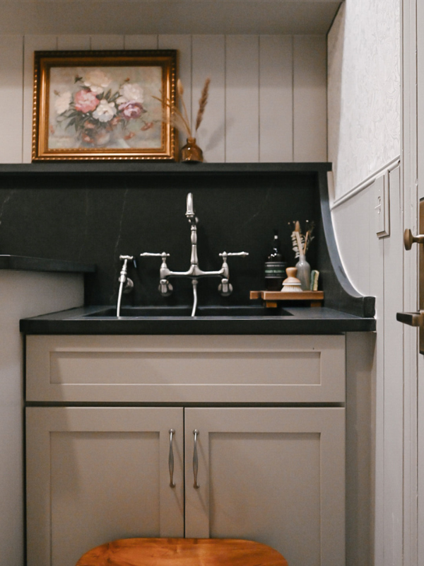 Light taupe shaker laundry room wall cabinets and sink base next to a washer/dryer and black quartz countertop Light taupe shaker laundry room wall cabinets and sink base next to a washer/dryer and black quartz countertop