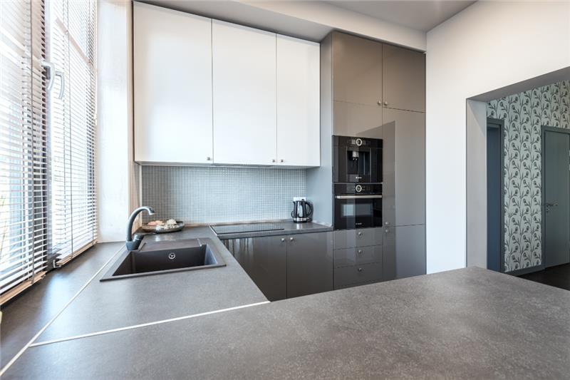 How to Choose the Right Finish for You U-shaped kitchen design and peninsula with white wall cabinets and gray base cabinets in high-gloss finish