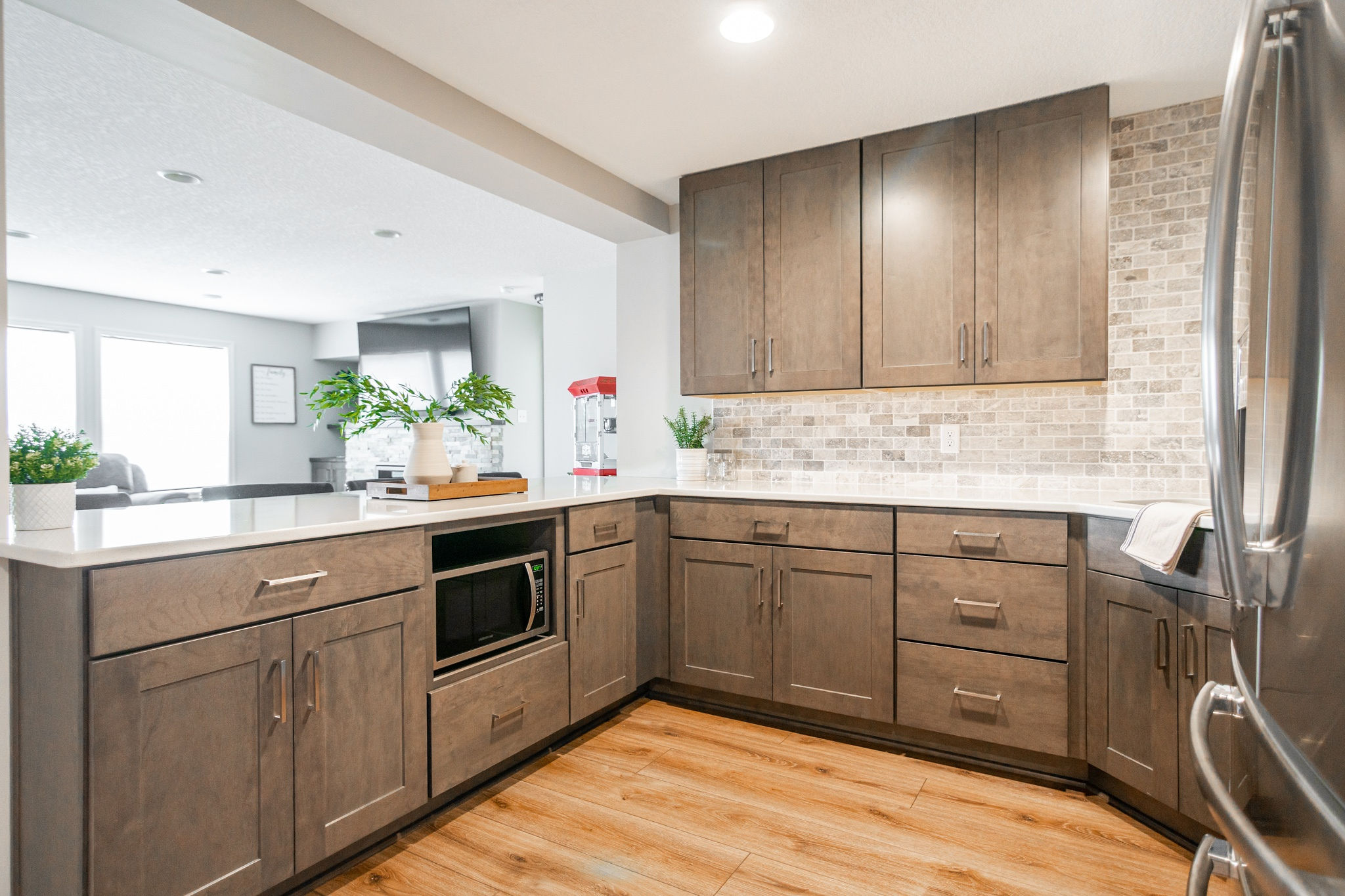 CliqStudios project: Warm wood shaker kitchen cabinets in a basement bar with tile backsplash CliqStudios project: Warm wood shaker kitchen cabinets in a basement bar with tile backsplash