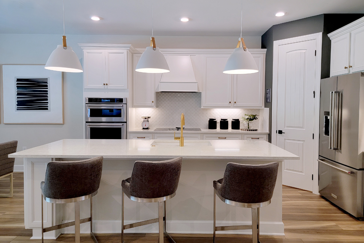 Large white shaker kitchen design with a kitchen island and large pendant lights Large white shaker kitchen design with kitchen island