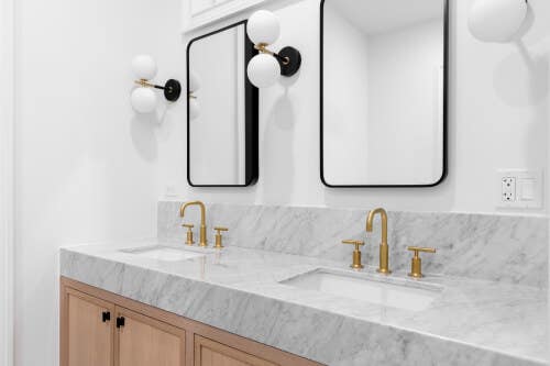 Light wood inset vanity cabinets with thick marble countertops Light wood inset vanity cabinets with thick marble countertops