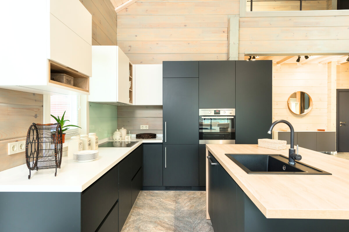 Matte vs. Glossy Finishes: Pros, Cons & Styling Tips for Cabinets L-shaped white and black matte kitchen cabinets with white quartz countertops and a black island