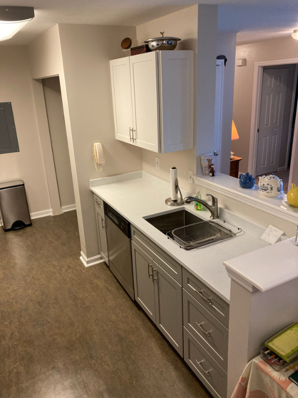 Shaker galley kitchen with white wall cabinets, gray base cabinets, and white quartz countertops Shaker galley kitchen with white wall cabinets, gray base cabinets, and white quartz countertops