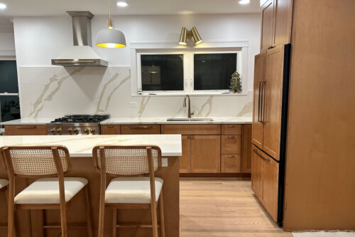 Newport Harvest kitchen cabinets L-shaped light maple cabinet kitchen with island and matching slab quartz backplash