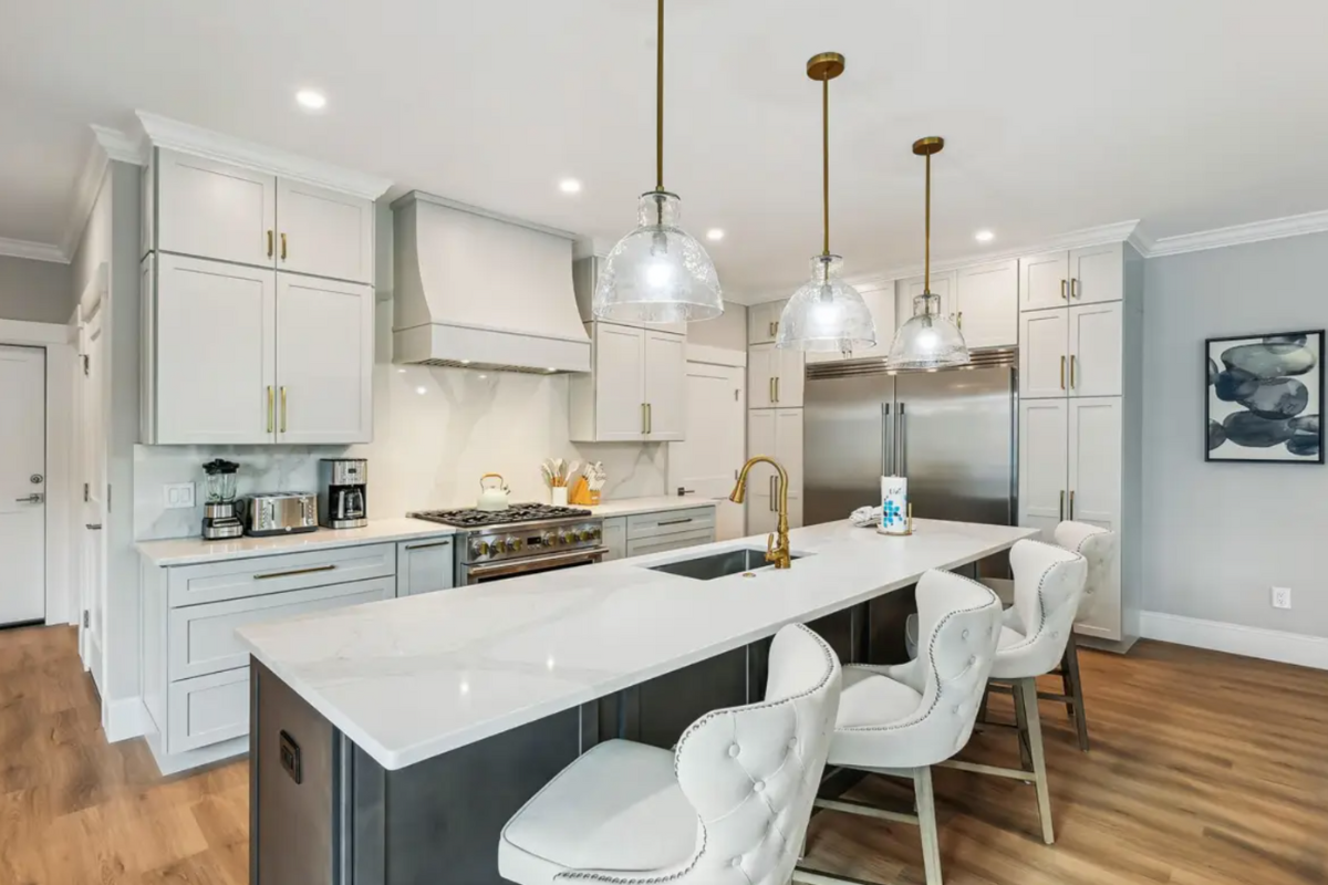Light gray stacked shaker kitchen design with dark gray stained island and white countertops Light gray stacked shaker kitchen design with dark gray stained island and white countertops