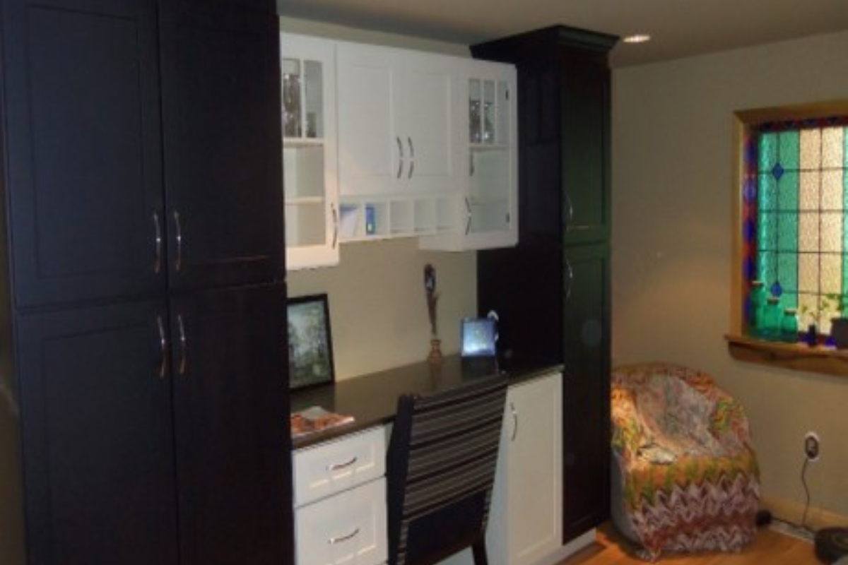 Built-in home office desk cabinets with black shaker pantries flanking white shaker drawer bases and mullion glass door wall cabinets Built-in home office desk cabinets with black shaker pantries flanking white shaker drawer bases and mullion glass door wall cabinets